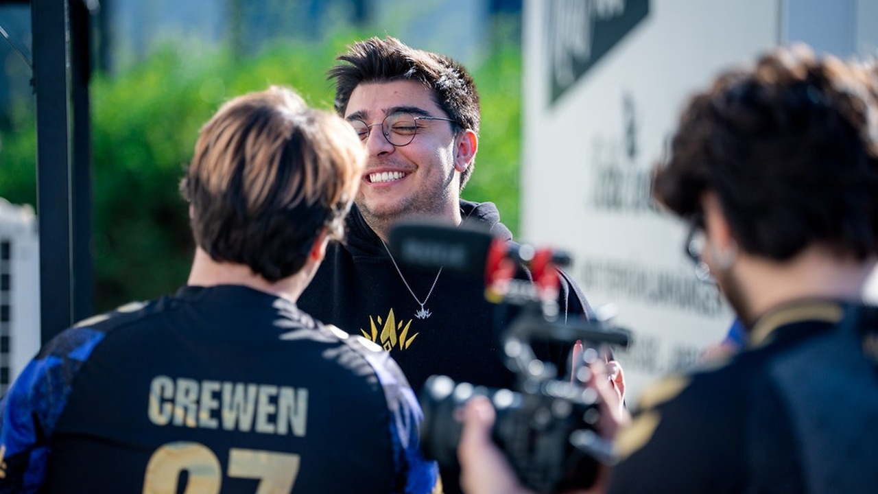 Игрок PCIFIC Esports улыбается рядом с камерами на сцене